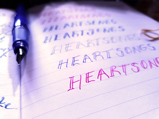 A Fountain pen lying on an open book with genuine ink writing.